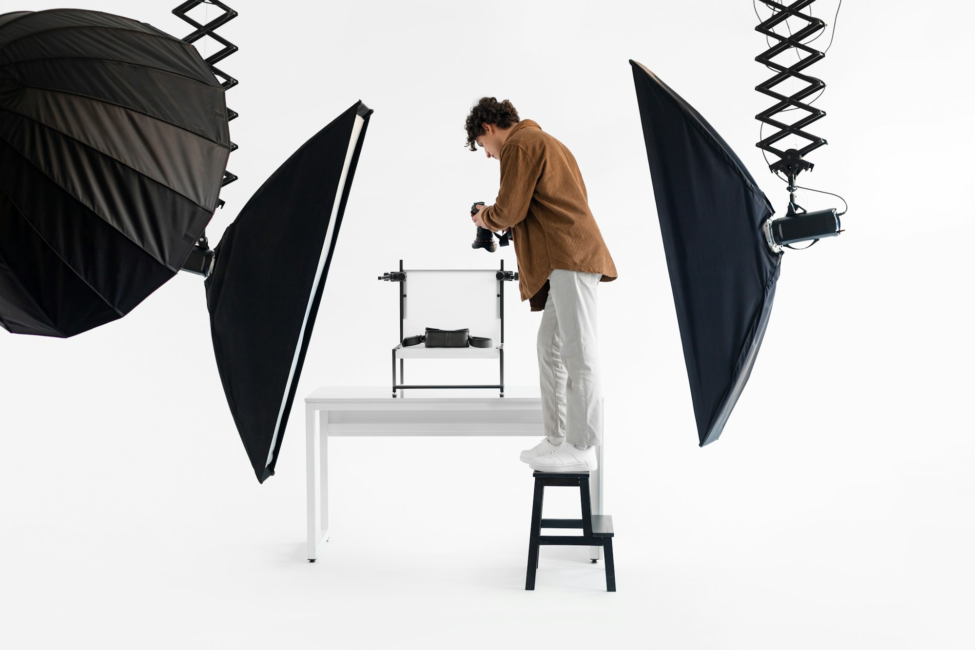 Photographer on stool in studio with lighting setup