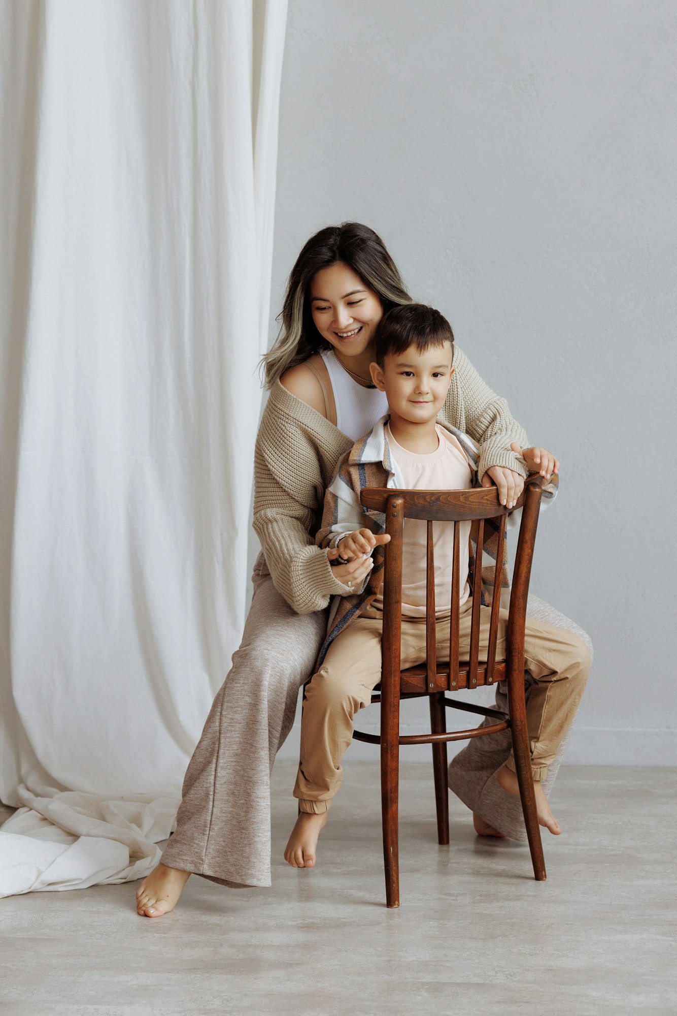 A mother and her son are hugging and smiling