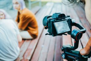 Backstage how operator working with professional camera on electronic steadicam. Videographer shoots